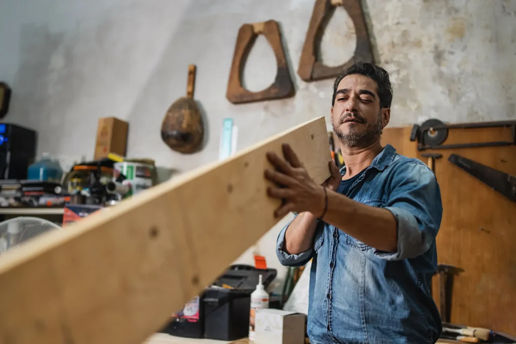 a carpenter visually checks a plank of wood in his 2025 03 08 16 49 11 utc